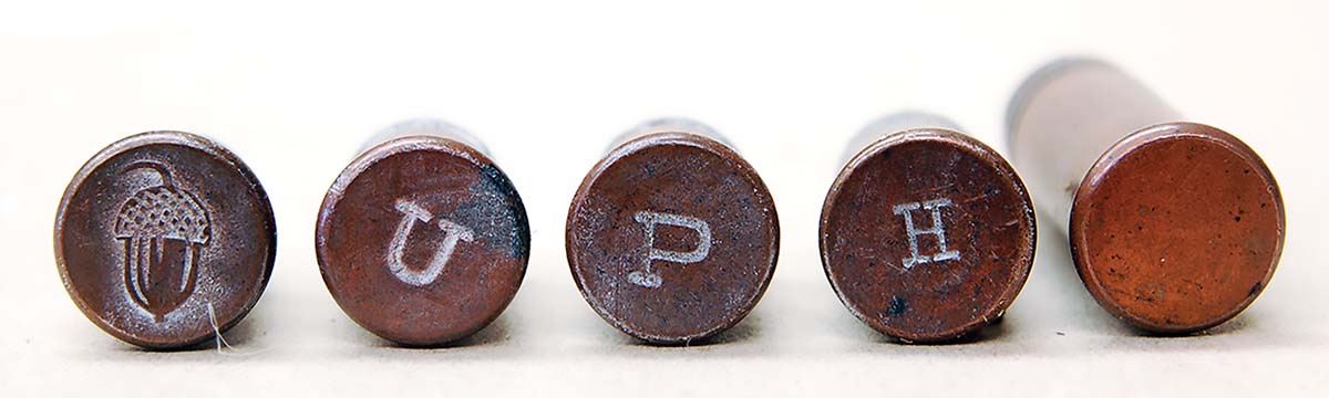 Early copper-cased 22 LRs had many headstamps, but mostly the one shown at far right – nothing at all!